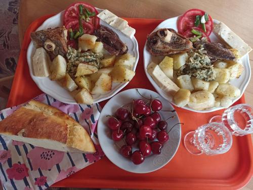 una bandeja con tres platos de comida y fruta. en Apartments & Rooms Vitko, en Žabljak