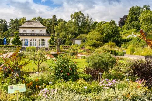 a garden with a large building in the background at Boutique Hotel Angerer in Murnau am Staffelsee