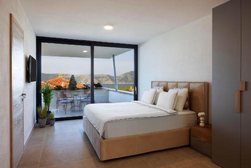a bedroom with a bed and a balcony with a table at FIRST RESIDENCE Villa Eternity in Linardići