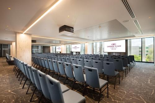 a conference room with a row of chairs and a screen at Crowne Plaza Adelaide by IHG in Adelaide