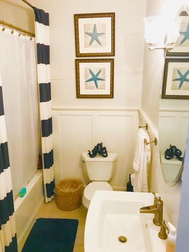 a bathroom with a white toilet and a sink at Waimea Bay Luxury Estate Views & Hot Tub in Haleiwa