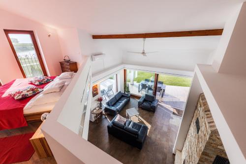 sypialnia na poddaszu z łóżkiem i 2 krzesłami w obiekcie Balaton View Apartment w mieście Balatonboglár