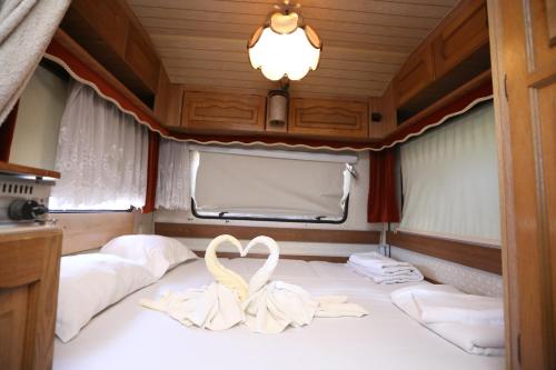 a swan decoration on a bed in a boat at Каравани на плаж Златна Рибка Созопол in Sozopol