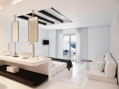 a white living room with a white couch and a table at Mykonos Earth Suites in Mýkonos City