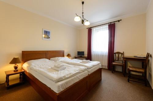 a bedroom with a bed and a desk and a window at Valdštejn in Liberec