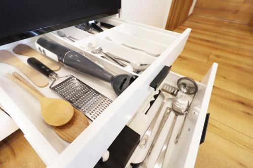 a white drawer filled with kitchen utensils at Appartements Eisenstein in Bayerisch Eisenstein
