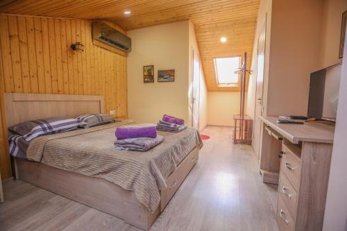 a bedroom with a bed with purple pillows on it at Dogona Apartment in Tbilisi City