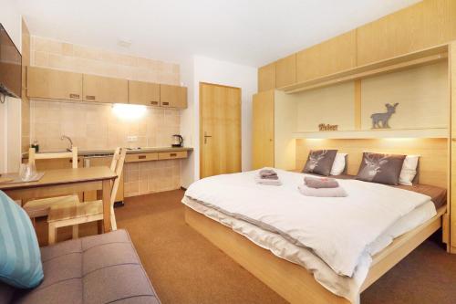 ein Schlafzimmer mit großem Bett und eine Küche in der Unterkunft Appartements Zum Arber in Bayerisch Eisenstein