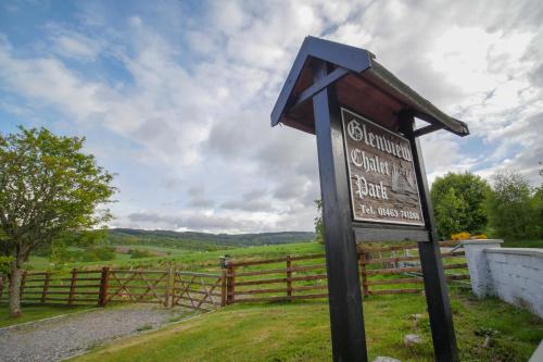 a sign in the grass next to a fence at Glenview Chalet Park in Inverness