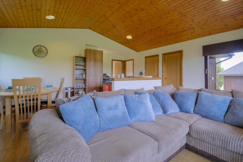 een woonkamer met een grote bank met blauwe kussens bij Glenview Chalet Park in Inverness