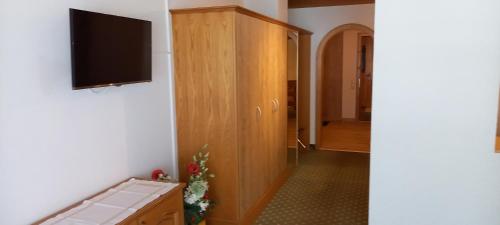 a hallway with a cabinet and a television on a wall at Pension Backstuba in Partenen