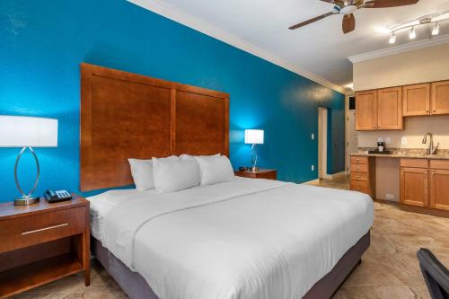 um quarto com uma cama grande e uma parede azul em SureStay Plus Hotel by Best Western The Villages em Lady Lake