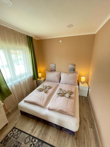 um quarto com uma cama grande com duas flores em Lilla Apartman em Balatonkeresztúr