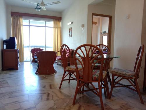 a dining room with chairs and a table and a window at GloRy BeAch ResOrt private apartment in Port Dickson