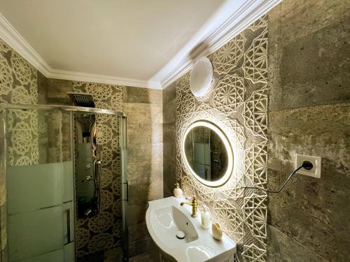 a bathroom with a sink and a mirror and a shower at La Konac in Murighiol