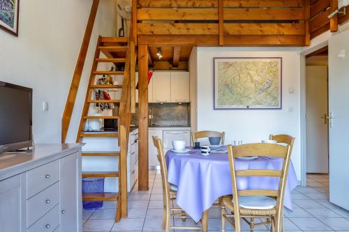 een eetkamer met een tafel met stoelen en een ladder bij Apartplage in Saint-Jorioz