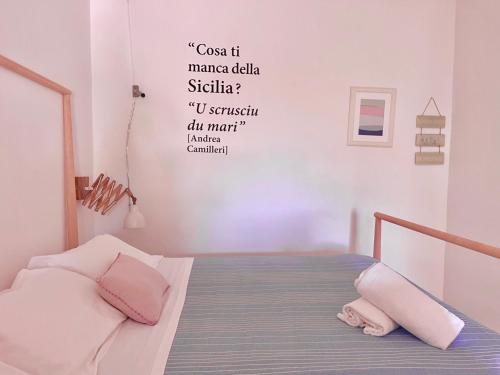 1 dormitorio con 1 cama con palabras en la pared en At the Seacily, en Fontane Bianche