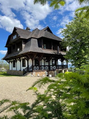 una gran casa de madera con techo de gambrel en Blyzhche Neba, en Yablunytsya