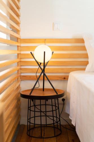 a table with a lamp on it next to a bed at FONTE SANTA Manor House in Vila Nova de Gaia