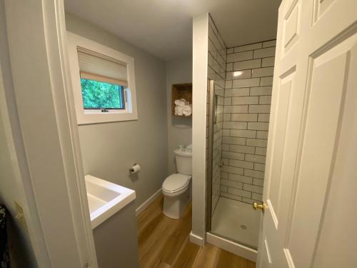 a bathroom with a tub and a toilet and a window at Hanscom's Motel & Cottages in Bar Harbor