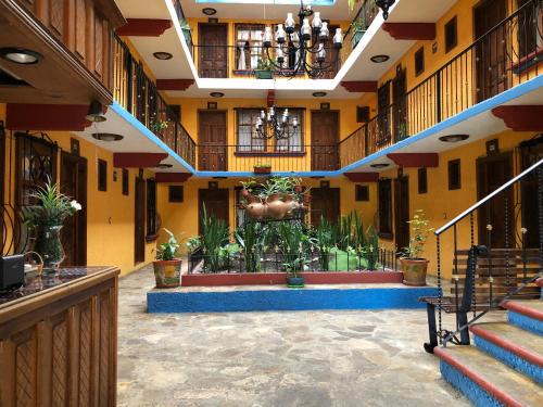 a lobby with stairs and plants in a building at Hotel Tradicional in San Cristóbal de Las Casas