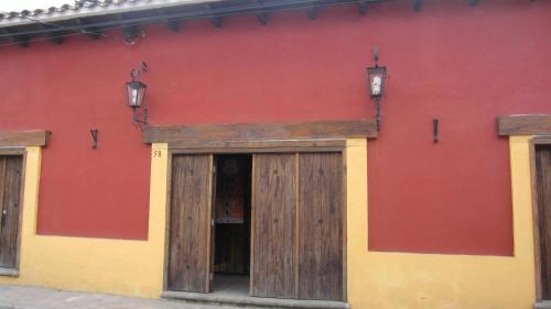 a red and yellow building with a wooden door at Hotel Tradicional in San Cristóbal de Las Casas