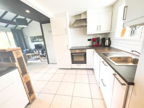 a kitchen with white cabinets and a white tile floor at Le Vieux Sart 14 in Stavelot