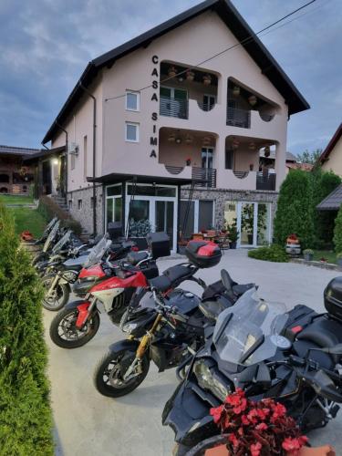 una fila de motocicletas estacionadas frente a un edificio en Casa Sima, en Curtea de Argeş