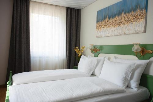 a bedroom with two beds with white sheets and a window at Hotel La Balance self check-in in Biel