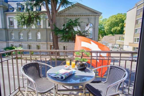 a table and chairs on a balcony with a building at Hotel La Balance self check-in in Biel