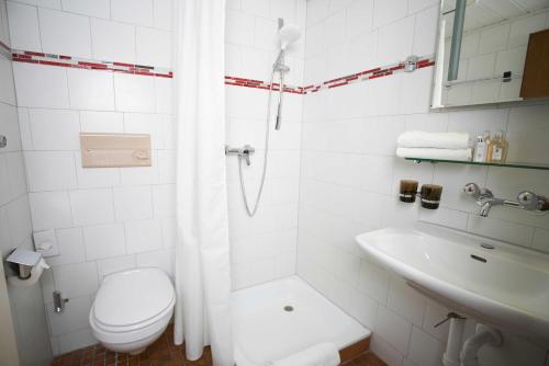 a white bathroom with a toilet and a sink at Hotel La Balance self check-in in Biel