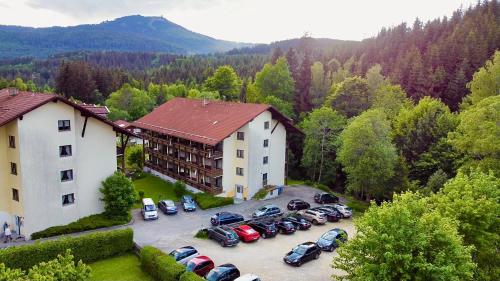 une vue aérienne sur un hôtel avec des voitures garées dans un parking dans l'établissement Appartements Zum Arber, à Bayerisch Eisenstein