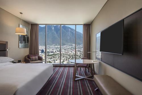um quarto de hotel com uma cama e uma televisão de ecrã plano em Fiesta Americana Monterrey Pabellón M. em Monterrey