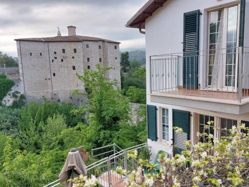 a building with a balcony with a castle in the background at FuriaForte! in Ascoli Piceno