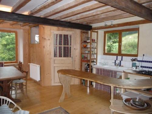 uma cozinha com uma mesa de madeira e uma bancada em Terre Rouge em Boulc