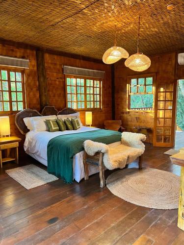a bedroom with a bed and a table and windows at Confraria Colonial Hotel Boutique in Mairinque