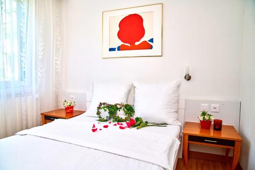 a bedroom with a white bed with flowers on it at Hotel La Balance self check-in in Biel