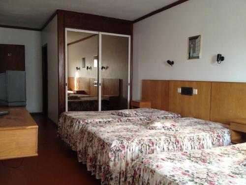 a hotel room with two beds and a mirror at RS Sobreiro in Aves