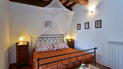 een slaapkamer met een bed met een klamboe bij Villa Nocciola Il Poderone in Roccalbegna