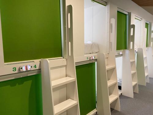 a locker room with green and white walls and shelves at Capsule in Kasakake MALE ONLY - Vacation STAY 72924v in Midori