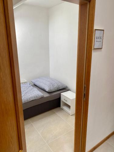 a small bedroom with a bed and a night stand at Ubytování U Pivovaru in Kamenice nad Lipou