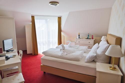 a bedroom with a large white bed and a window at Parkhotel Wörlitz in Oranienbaum-Wörlitz