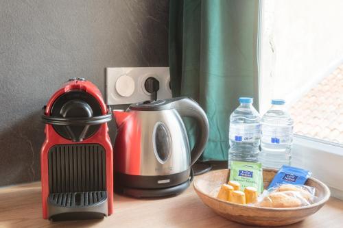 a kitchen counter with a toaster and a bowl of fruit at Cosy Apparts Saintes in Saintes