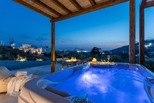 a jacuzzi tub in a house with a view at Naxos Pantheon Luxury Apartments in Agkidia