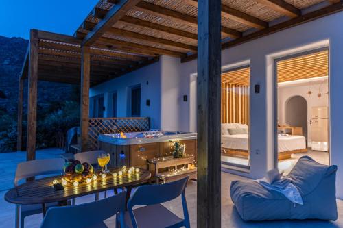 a patio with a table and chairs and a bed at Naxos Pantheon Luxury Apartments in Agkidia