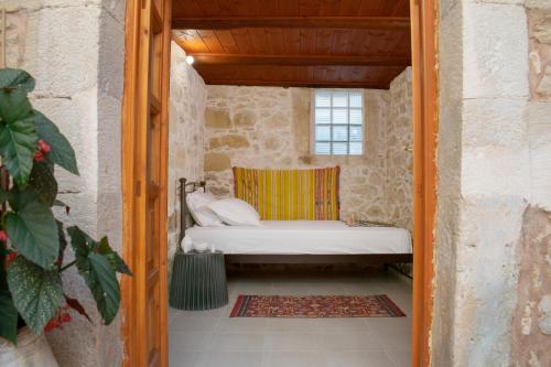 Habitación pequeña con cama en un edificio de piedra en CASA CANTICO, en Margarítai