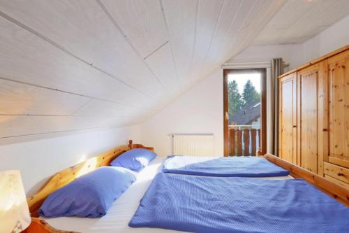 1 dormitorio con 1 cama grande con almohadas azules en Ferienhaus Anne mit Sauna, See, Wald und Ruhe en Kirchheim