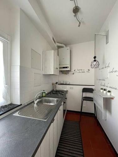 a white kitchen with a sink and a stove at La casa del mare in Savona