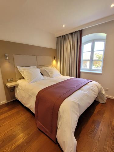 a large bed in a bedroom with a window at LODGES EN PIERRES DOREES in Saint-Germain-Nuelles
