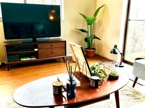 a living room with a coffee table and a flat screen tv at Yatsugatake Villa Masaki - Vacation STAY 74331v in Hokuto